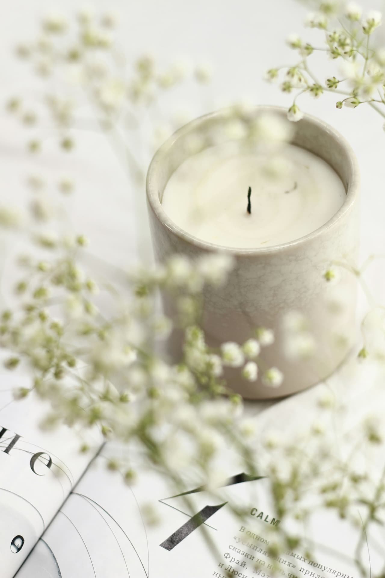 Vela clara rodeada de flores suaves para elegir aromas de regalo